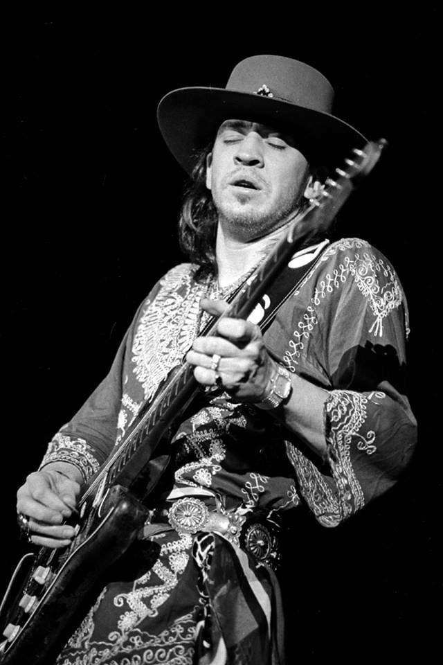 Stevie Ray Vaughan tocando guitarra no palco